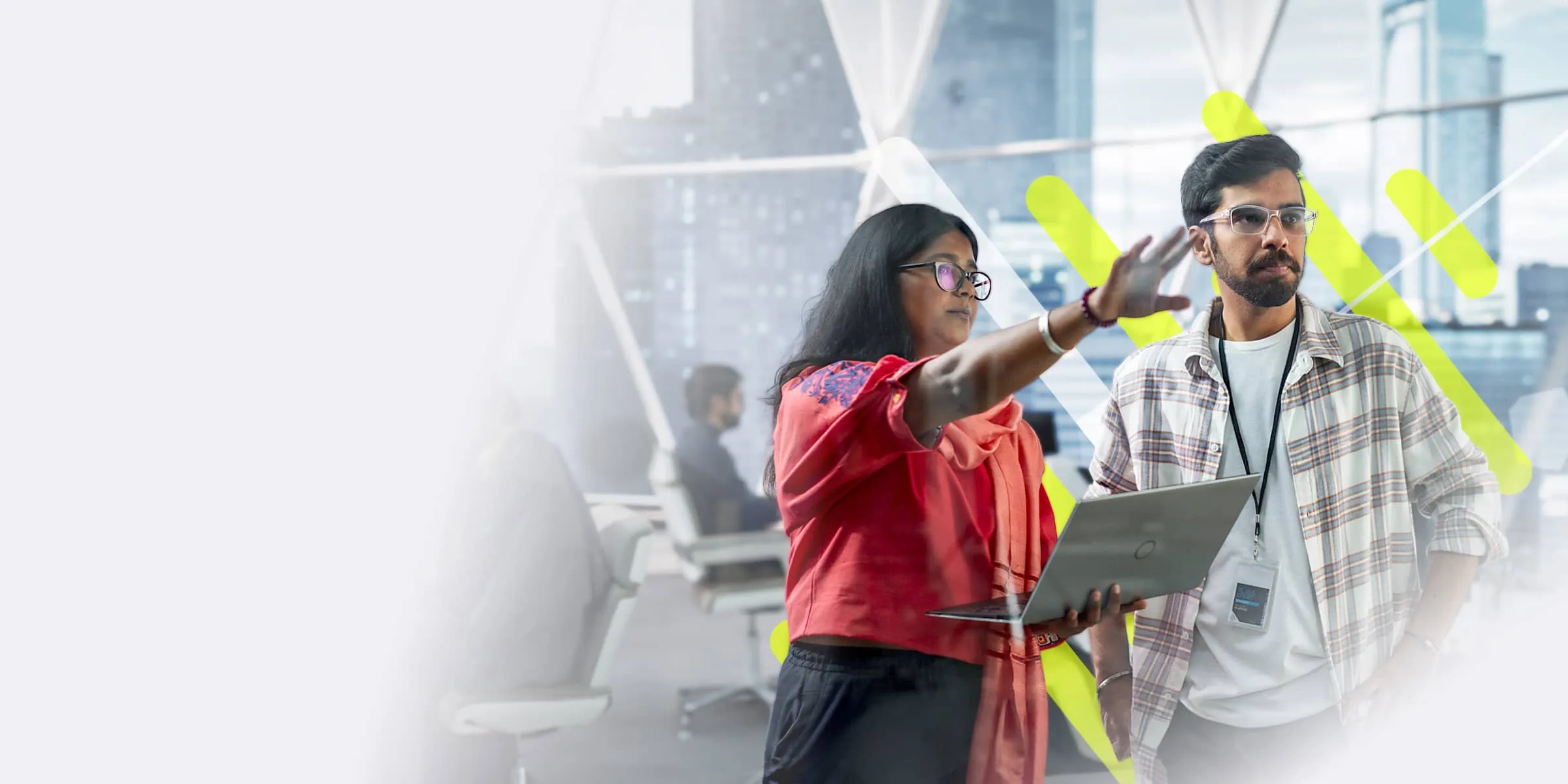 A male and female colleague discuss work whilst both looking a display screen